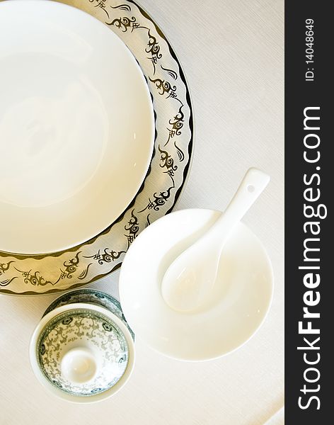 The tableware of china, plate and cup , bowl, spoon, on white. The tableware of china, plate and cup , bowl, spoon, on white