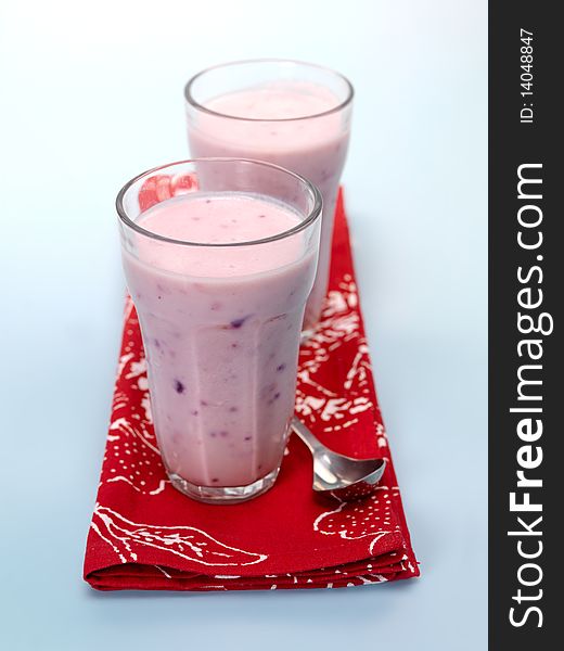 Mixed Berry Smoothie isolated against a blue background. Mixed Berry Smoothie isolated against a blue background