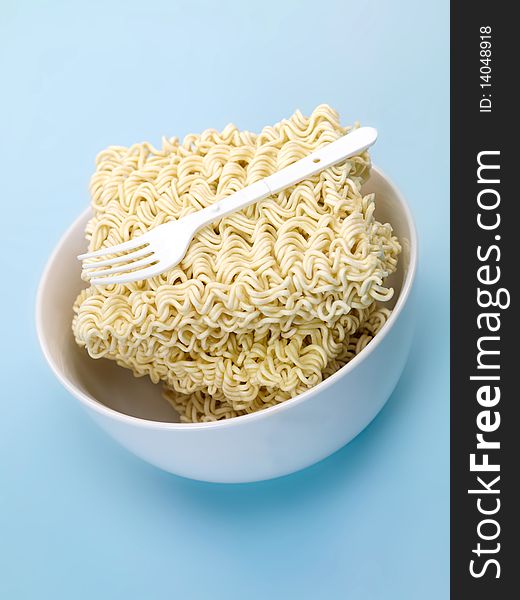 Dry instant noodles isolated against a blue background