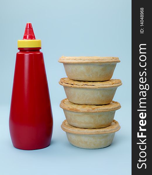A stack of Australian meat pies isolated against a blue background