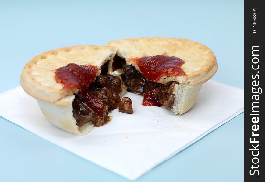 An Australian meat pie isolated against a blue background