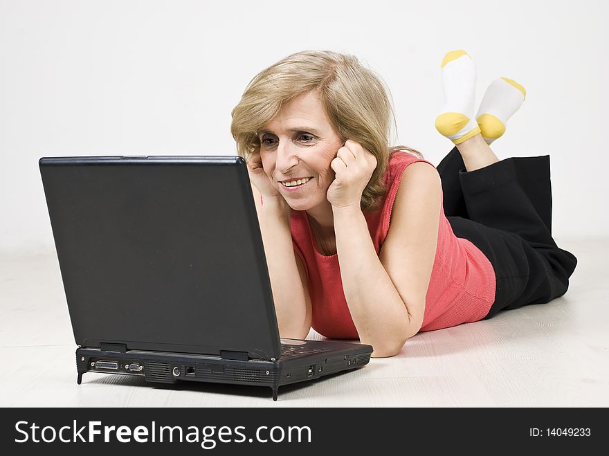 Senior woman lying down on white wooden floor and using a laptop,see more in <a href=http://www.dreamstime.com/people-on-couch-or-wooden-floor-rcollection11965-resi828293>People on couch or wooden floor</a>. Senior woman lying down on white wooden floor and using a laptop,see more in <a href=http://www.dreamstime.com/people-on-couch-or-wooden-floor-rcollection11965-resi828293>People on couch or wooden floor</a>