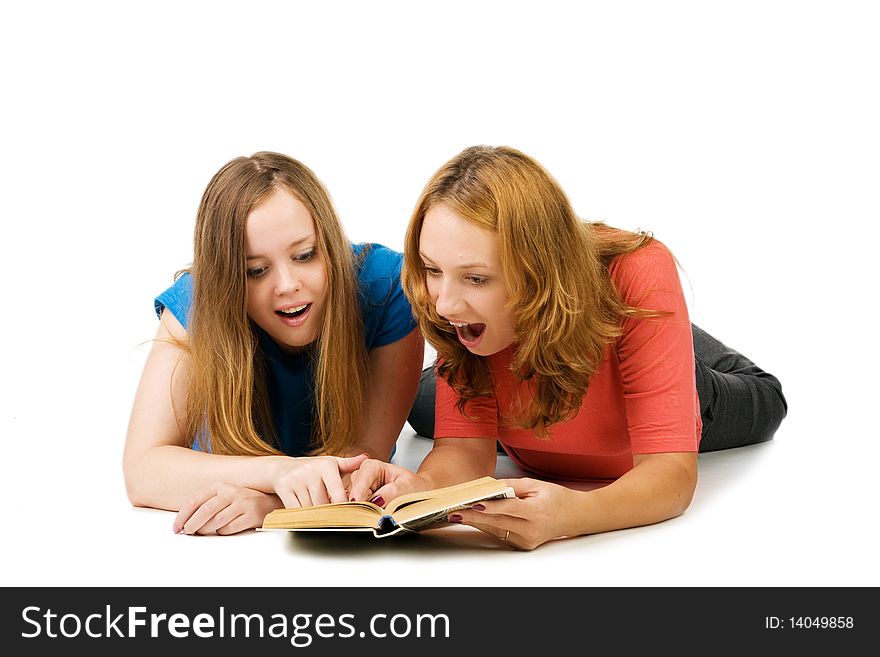 Two surprised girls read the book, isolated on white. Two surprised girls read the book, isolated on white