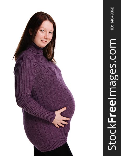 The beautiful pregnant woman in a violet sweater embraces stomach, isolated on white. The beautiful pregnant woman in a violet sweater embraces stomach, isolated on white