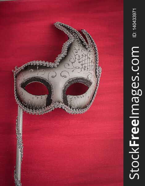 Colorful carnival mask on a red textured background. Masks with theater concept. Top view with copy space