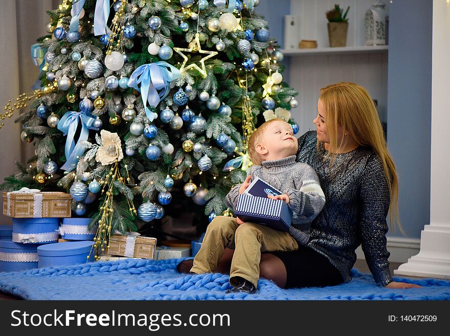 Happy family mother and baby little son playing home on Christmas holidays. New Year`s holidays.