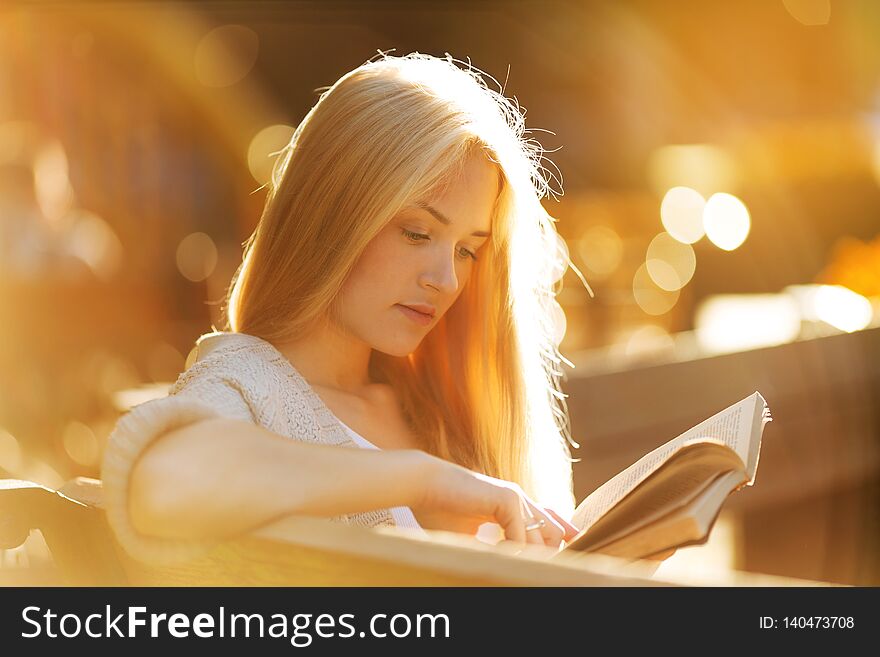 Beautiful girl sits and reads an interesting book. Beautiful girl sits and reads an interesting book