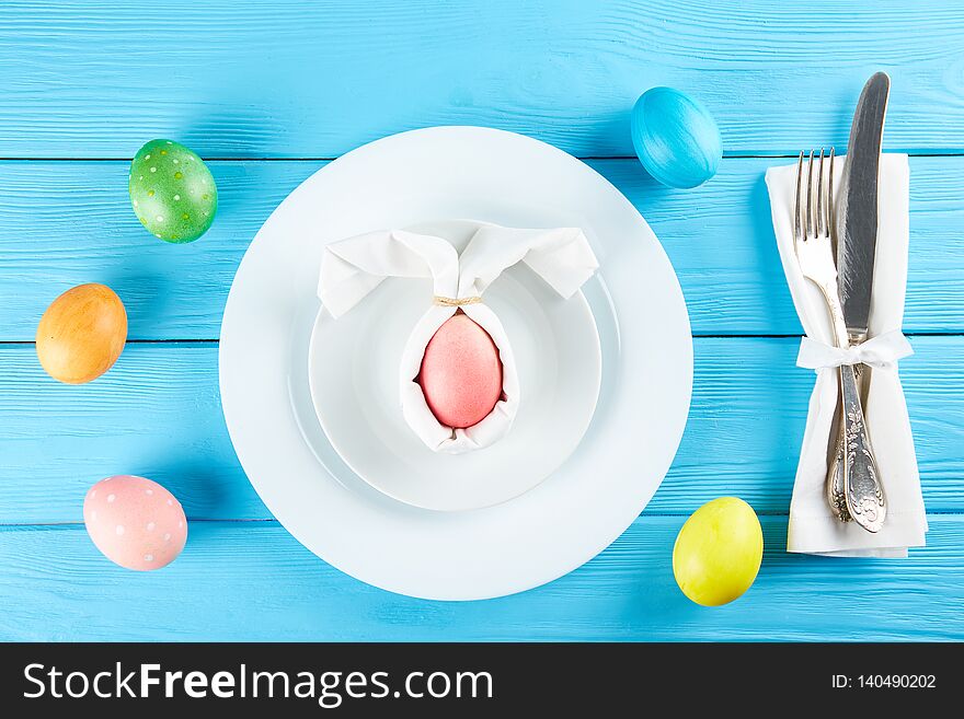 Table setting arrangement in minimal style with easter spring holiday attributes, fork, knife and napkin. Background, copy space, close up, flat lay, top view. Table setting arrangement in minimal style with easter spring holiday attributes, fork, knife and napkin. Background, copy space, close up, flat lay, top view