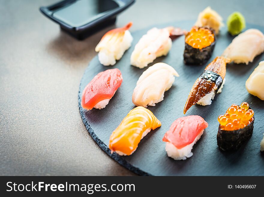 Nigiri sushi set with salmon tuna fish shrimp prawn eel shell and other sashimi on black slate - Japansese food style. Nigiri sushi set with salmon tuna fish shrimp prawn eel shell and other sashimi on black slate - Japansese food style