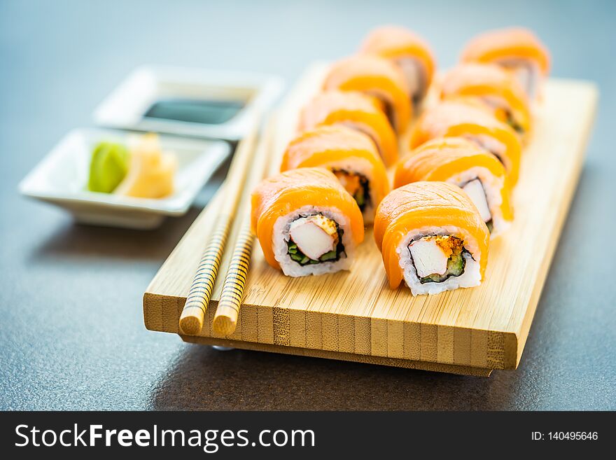 Salmon fish meat sushi roll maki on wood plate