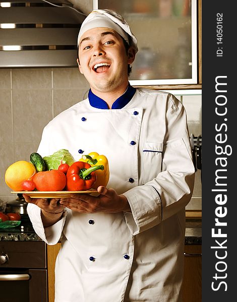 Happy man in form with vegetables on kitchen. Happy man in form with vegetables on kitchen