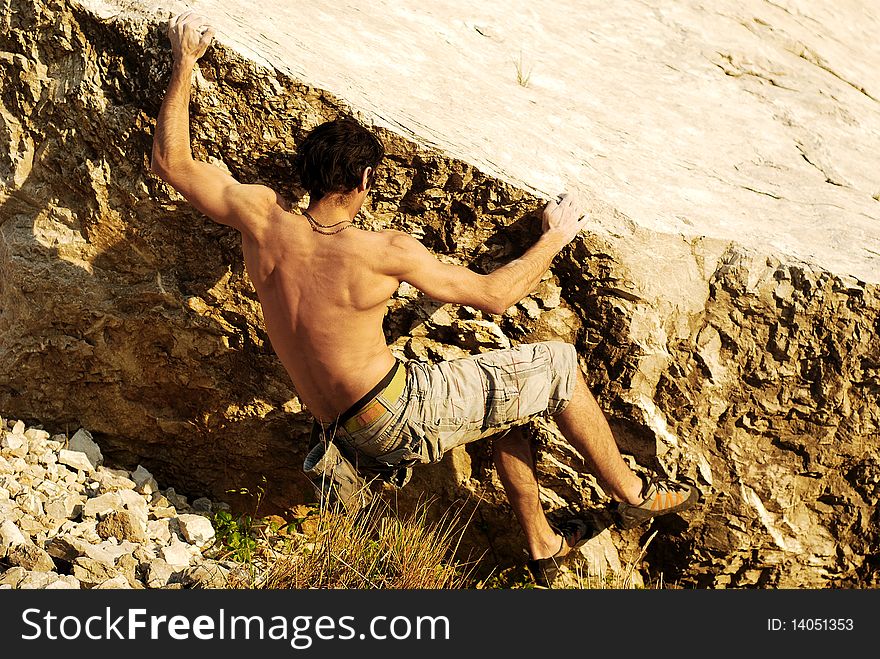 Climber climbing a limestone boulder. Climber climbing a limestone boulder