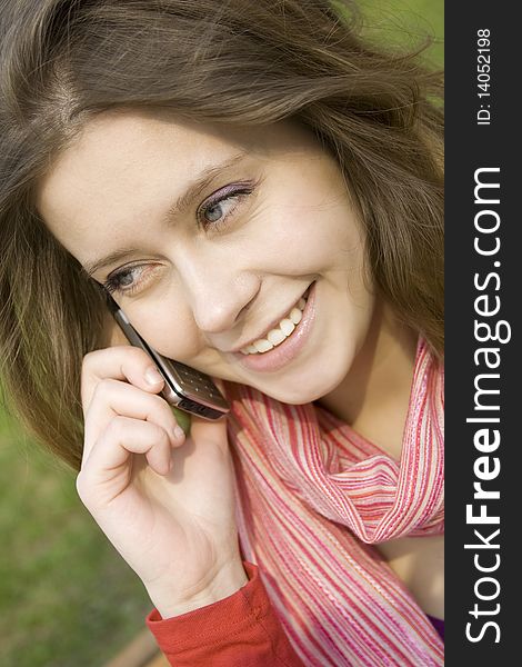 Young beautiful woman on the phone in the park. Young beautiful woman on the phone in the park