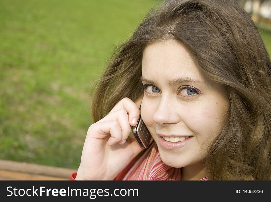 Young beautiful woman on the phone in the park. Young beautiful woman on the phone in the park