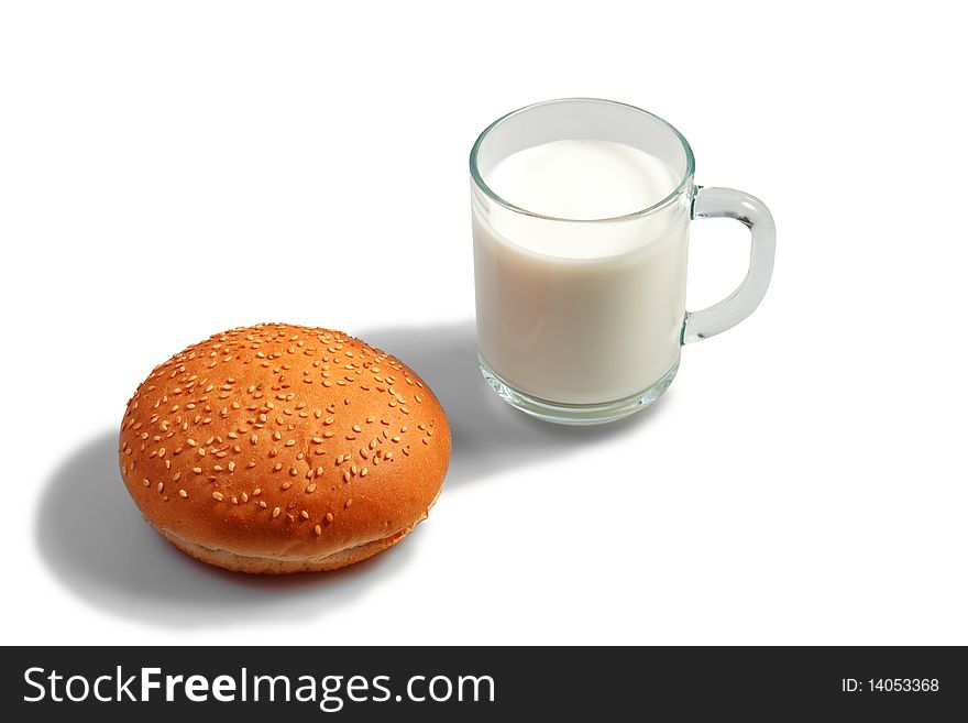 Glass of milk and bun on table