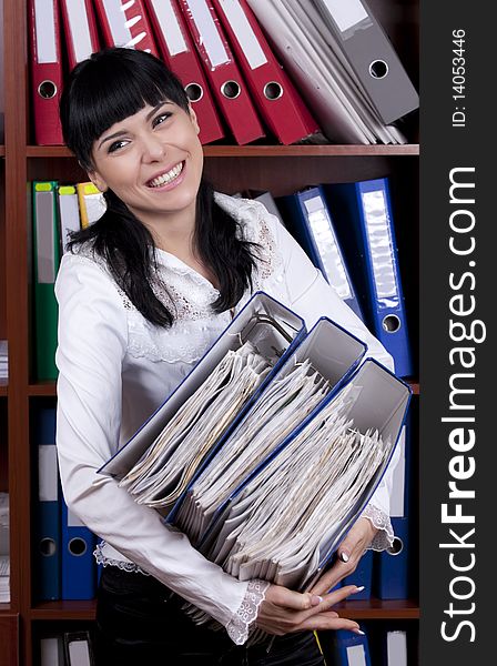 Smiling young secretary overloaded with files
