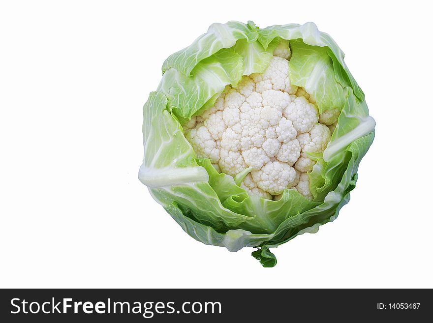 Fresh young cauliflower head with green leaves