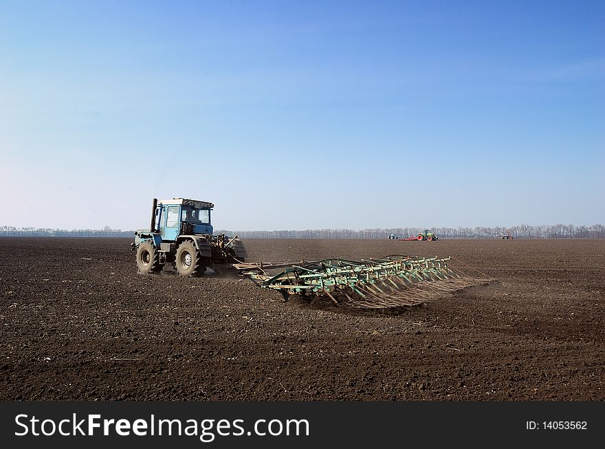 Tractor in the field sow wheat in the spring