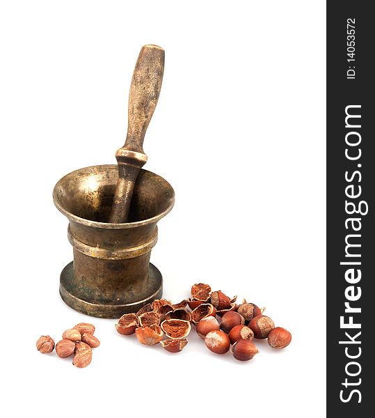 Brass mortar with pestle and nuts on white background