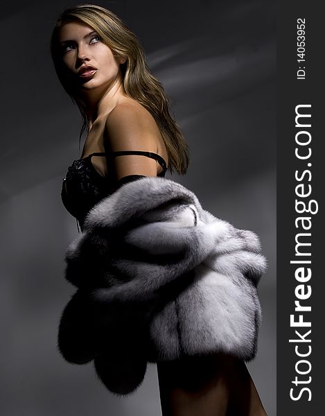 Attractive woman in fur coat looking up