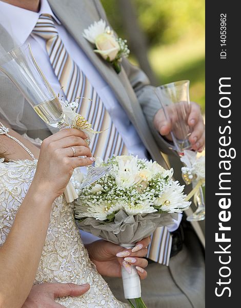 Bride and groom are holding champagne glasses