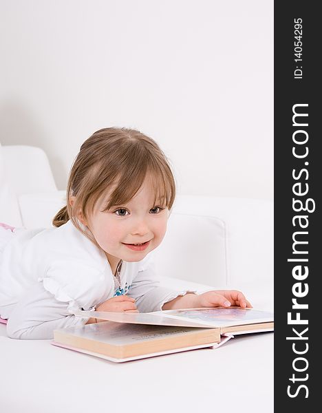 Sweet happy little girl reading book