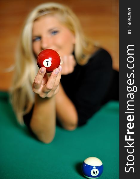 Beautiful woman holding a billiard ball. focus on the ball