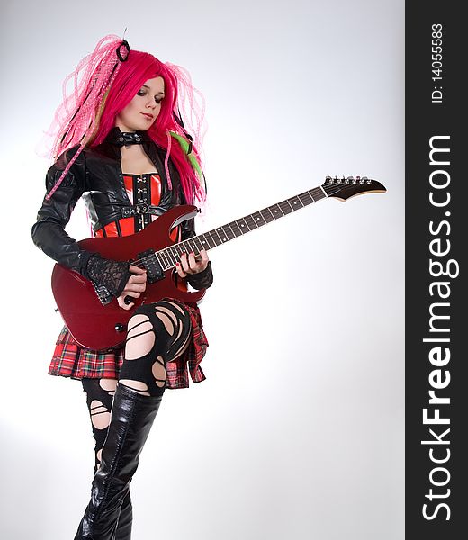 Gothic girl playing guitar, studio shot over white background