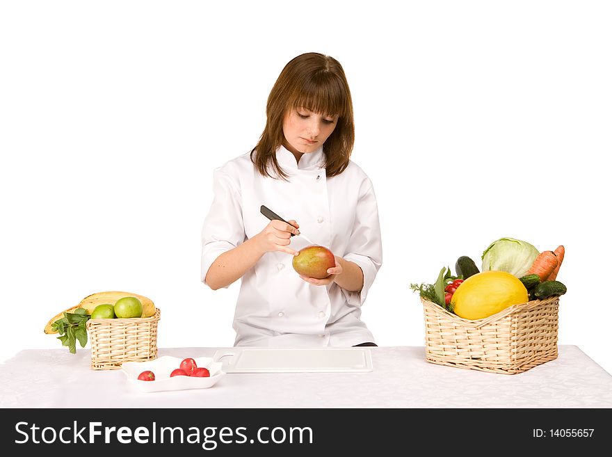 Cook girl makes carving a mango isolated on white background