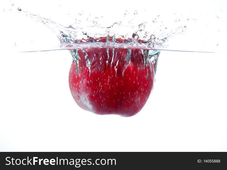 Red apple splashing into water