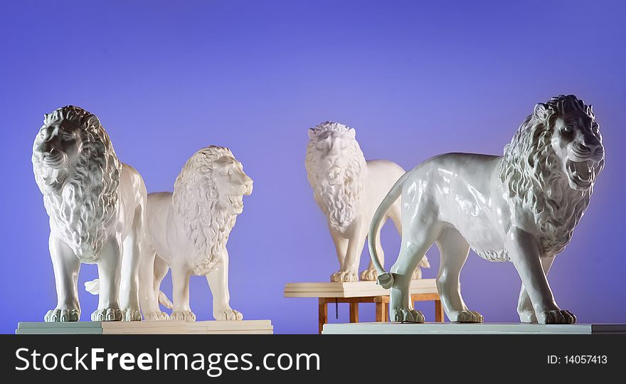 Four statues of lions on blue background. Four statues of lions on blue background