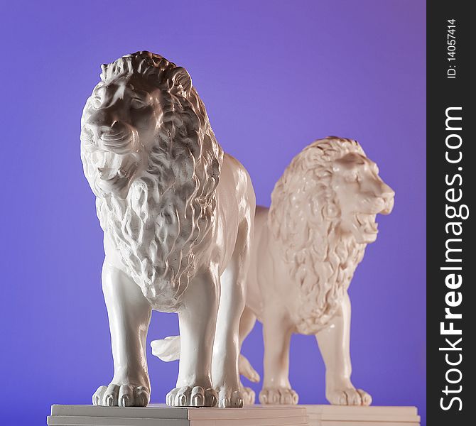 Two statues of lions on blue background. Two statues of lions on blue background