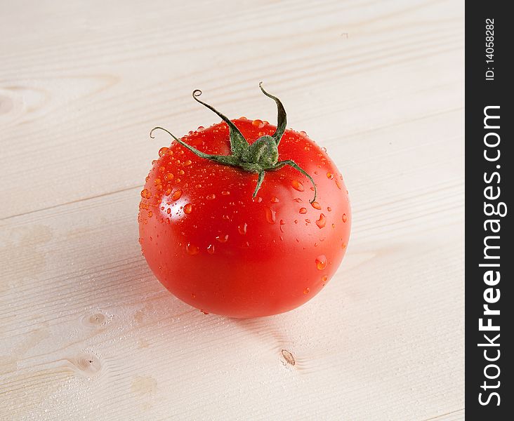 One fresh tomato in studio