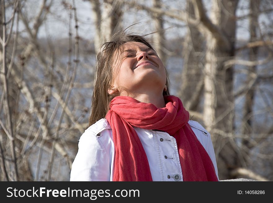 Portrait of a young beautiful girl in a red scarf. Outdoor scene. Close up.