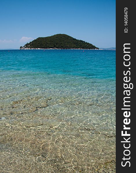 Calm blue Mediterranean beach with island in the distance. Calm blue Mediterranean beach with island in the distance