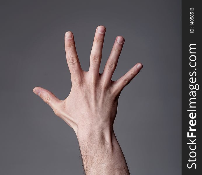 Hand showing finger up on grey background. Hand showing finger up on grey background