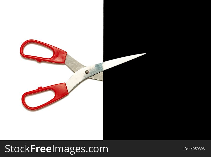 Scissors cutting a line between black and white