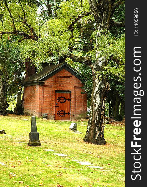 A red brick house in a cemetery. A red brick house in a cemetery