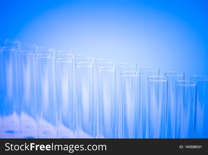 Laboratory test tubes,science background abstract. Glass test tubes in a stand on blue background