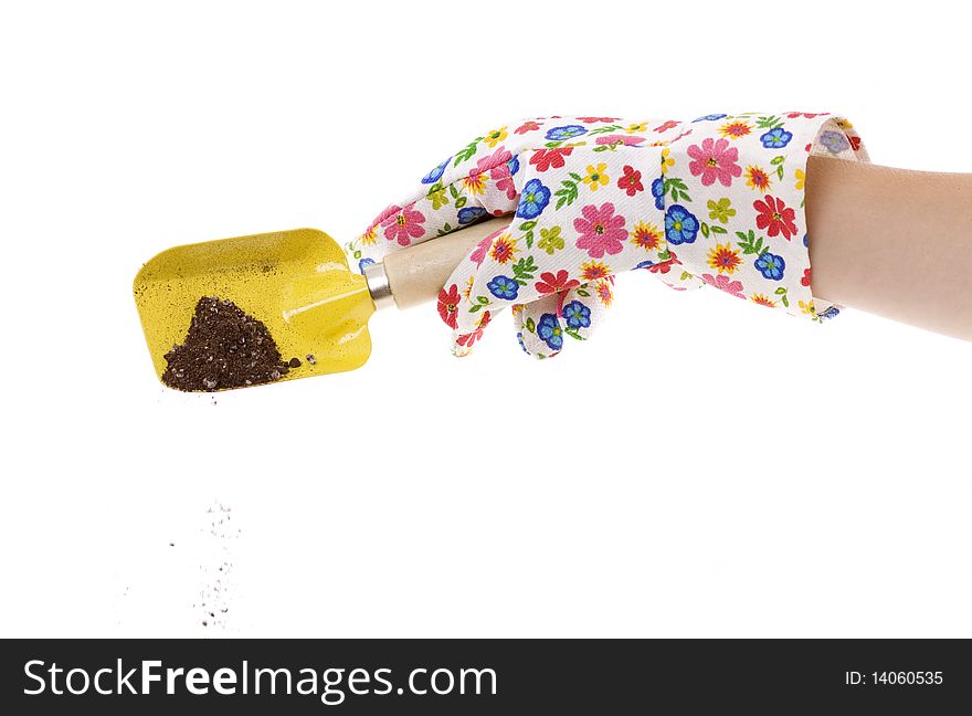 Gardener wearing colorful flower patterned  gardening glove is using a yellow shovel with soil in it.  isolated on white 6253. Gardener wearing colorful flower patterned  gardening glove is using a yellow shovel with soil in it.  isolated on white 6253