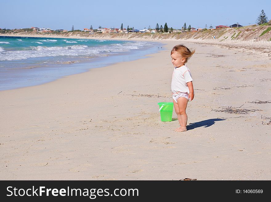 Charming little girl running on the golden beaches near the ocean blue