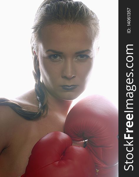 Woman in boxing gloves illuminated with backlight