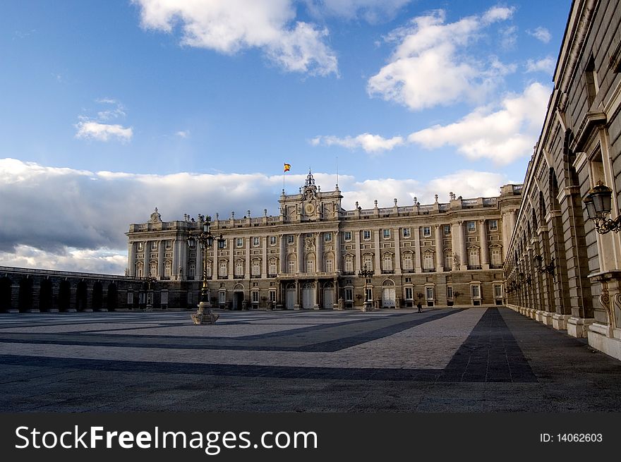 Daylight view of Madrid Royal Palace, surrounded by clouds