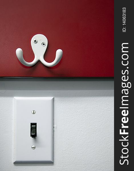 White coat hanger and white light switch. White coat hanger and white light switch