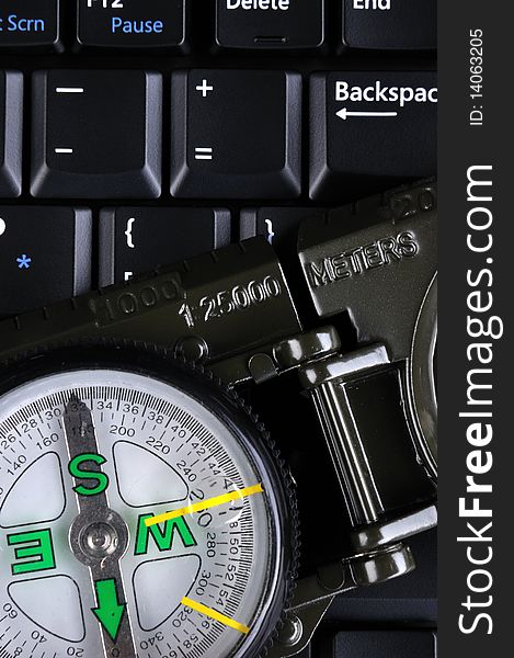 A compass and range finder putting on a computer keyboard, means direction concept, analysis, outting or travel. A compass and range finder putting on a computer keyboard, means direction concept, analysis, outting or travel.