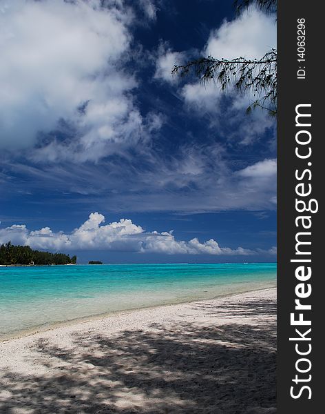 A beautiful white sand beach on Moorea island we majestic white clouds building on the horizon. A beautiful white sand beach on Moorea island we majestic white clouds building on the horizon.