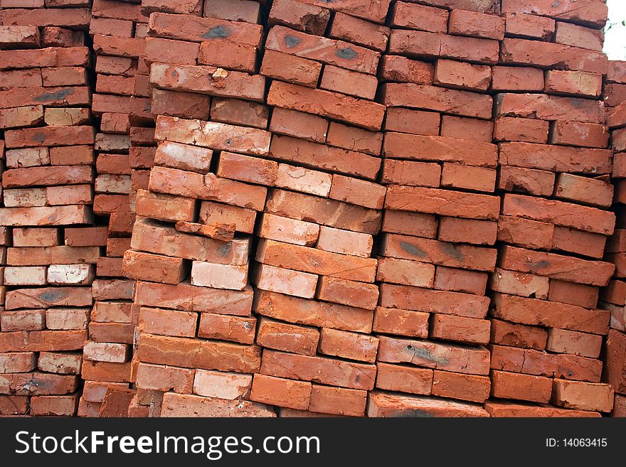 Heap of a red ceramic brick. A background on a theme about a building material.