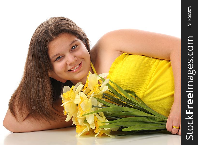 A beautiful young teen reclining in a yellow sundress while holding a bouquet of daffodils.  Isolated on white. A beautiful young teen reclining in a yellow sundress while holding a bouquet of daffodils.  Isolated on white.