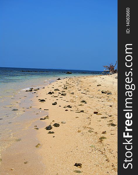 A rocky shore under a cloudless blue sky. A rocky shore under a cloudless blue sky