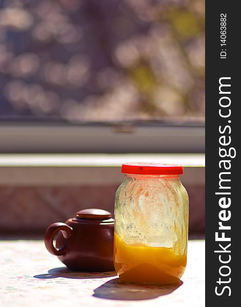 Breakfast on the sunny kitchen on spring (tea, honey, sugar, fruits)